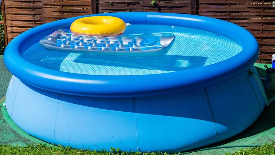 Aufblasbarer Pool im Garten mit aufblasbarer Matratze und gelbem Schwimmring